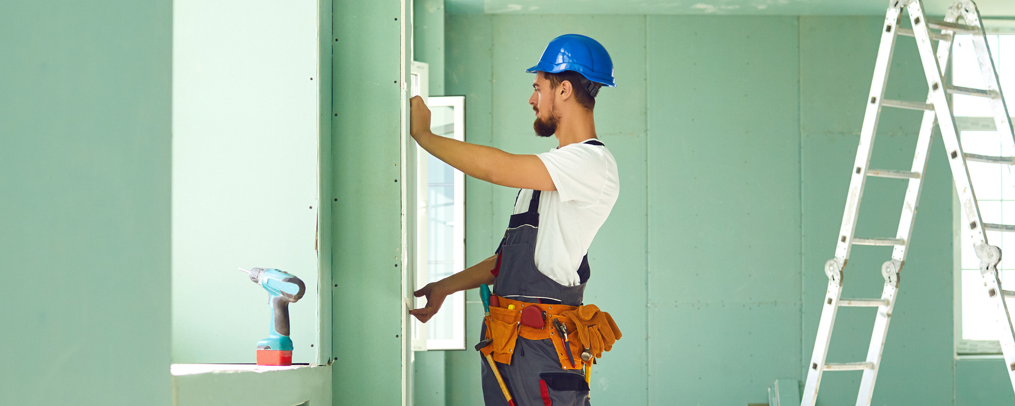 Worker builder installs plasterboard drywall